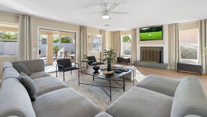 A spacious living room with a sofa, coffee table, and TV. - Brand New Luxury 5BR | Pool, Hot Tub & Mini Golf (Mesa)