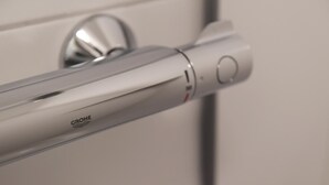 Un asa metálico con el logotipo de GROHE, que indica un diseño de grifo de alta gama.