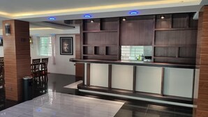 A modern kitchen with dark wood cabinetry, a central island, and recessed lighting. - Motel Minbu (Minbu)