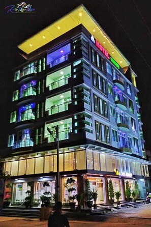Un hôtel à plusieurs étages, reconnaissable à son grand panneau « Motel », à ses grandes fenêtres et à ses balcons.