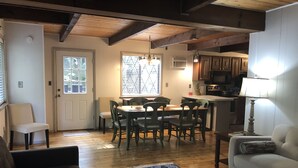 A dining area with a wooden table and chairs, a kitchen with a microwave, and a living room with a sofa and a patterned rug. - Facilities all year round (Bushkill)