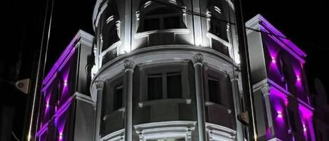 Un hotel con un diseño arquitectónico clásico, que cuenta con una cúpula central y un cartel.