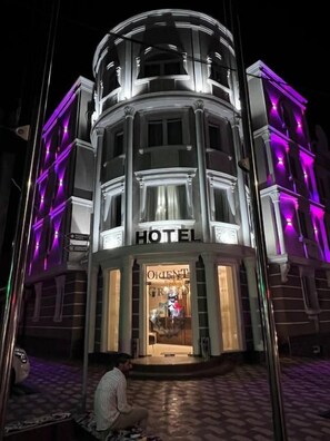A hotel with a classic architectural design, featuring a central dome and a signboard.