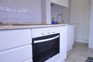 Een koelkast met diepvriezer, een microgolfoven, een oven, een kookplaat