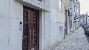 Eine enge Kopfsteinpflasterstraße, gesäumt von Gebäuden, mit einem Metallgitter und einem Schild.