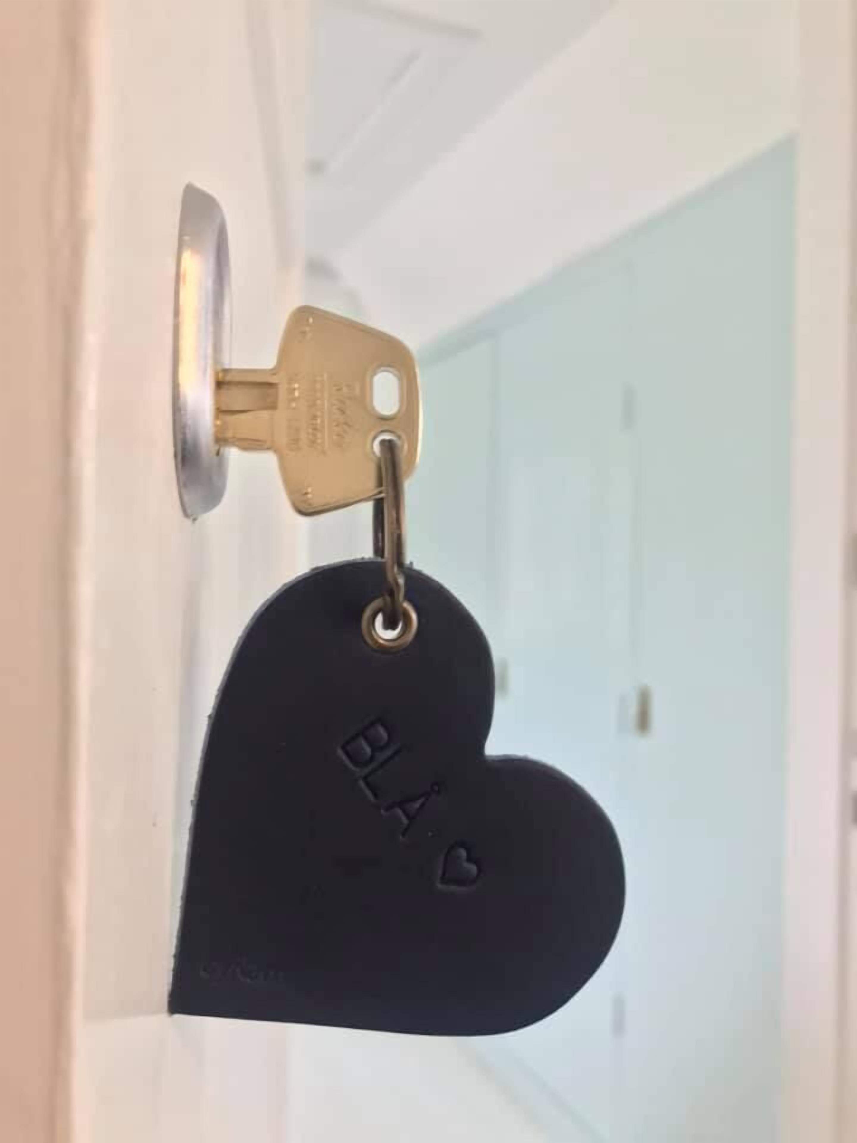 A key with a heart-shaped keychain that has "BLA" and a heart engraved on it.