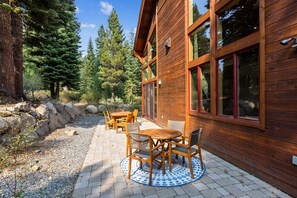 Una cabaña de madera con un patio que tiene una mesa y sillas.