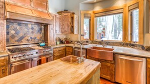 A kitchen with a large stove, sink, and wooden cabinets.