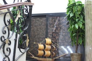A staircase with ornate black metal railings and a ship model in the background. - Hostel Le Coin D or (Algiers)