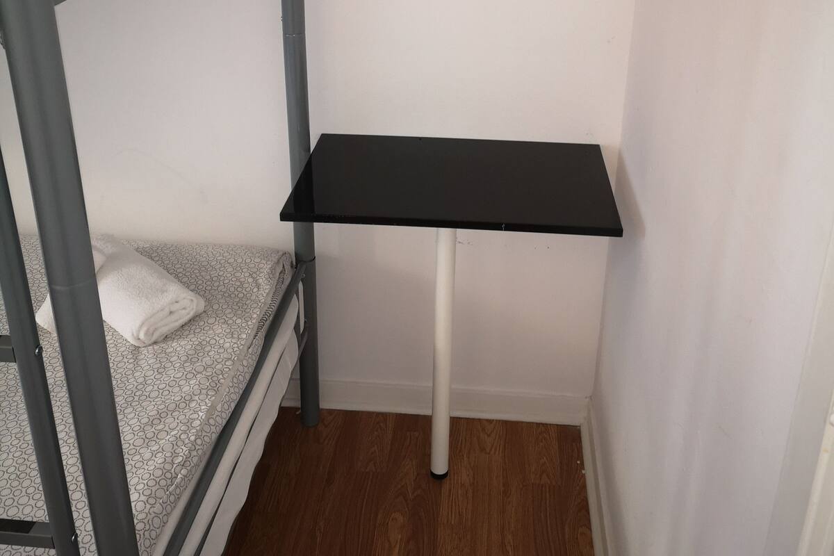 Uma cama beliche com escrivaninha em um quarto pequeno.
