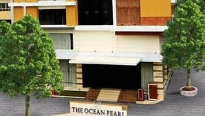 A modern hotel with a sign reading "The Ocean Pearl Inn." - Ocean Pearl Inn (Mangaluru)