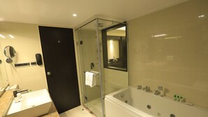 A modern bathroom with a glass-enclosed shower, a large bathtub, a sink, and a mirror. - Ocean Pearl Inn (Mangaluru)