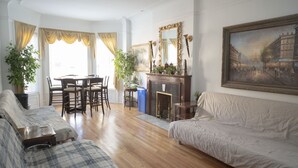 Un salon avec une cheminée, un coin repas et un canapé.