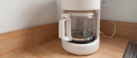 A Proctor Silex coffee maker on a wooden countertop.