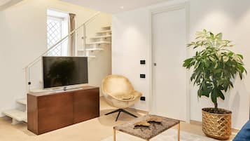 Habitación Deluxe (duplex) | Área de sala de estar | Televisión LED de 49 pulgadas con canales digitales y televisión