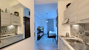A narrow hallway leading to a bedroom with a bunk bed, a small table, and a kettle. - Il Cavalliere Bed & breakfast (Barletta)