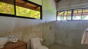 A modern bathroom with a glass shower enclosure, a wooden vanity with a bowl sink, and a toilet. - Drake Bay Greenleaf (Drake Bay)