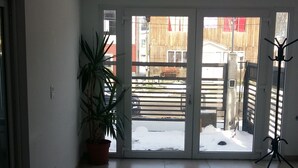 A spacious room with a tiled floor, a potted plant, and a tripod.