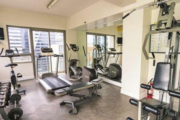 A gym with treadmills, elliptical machines, and weightlifting equipment. - Asia Premier Residences Cebu IT Park (Cebu City)