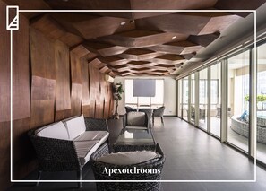 A modern lounge area with a wooden ceiling, comfortable seating, and large windows offering views of the city. - Asia Premier Residences Cebu IT Park (Cebu City)