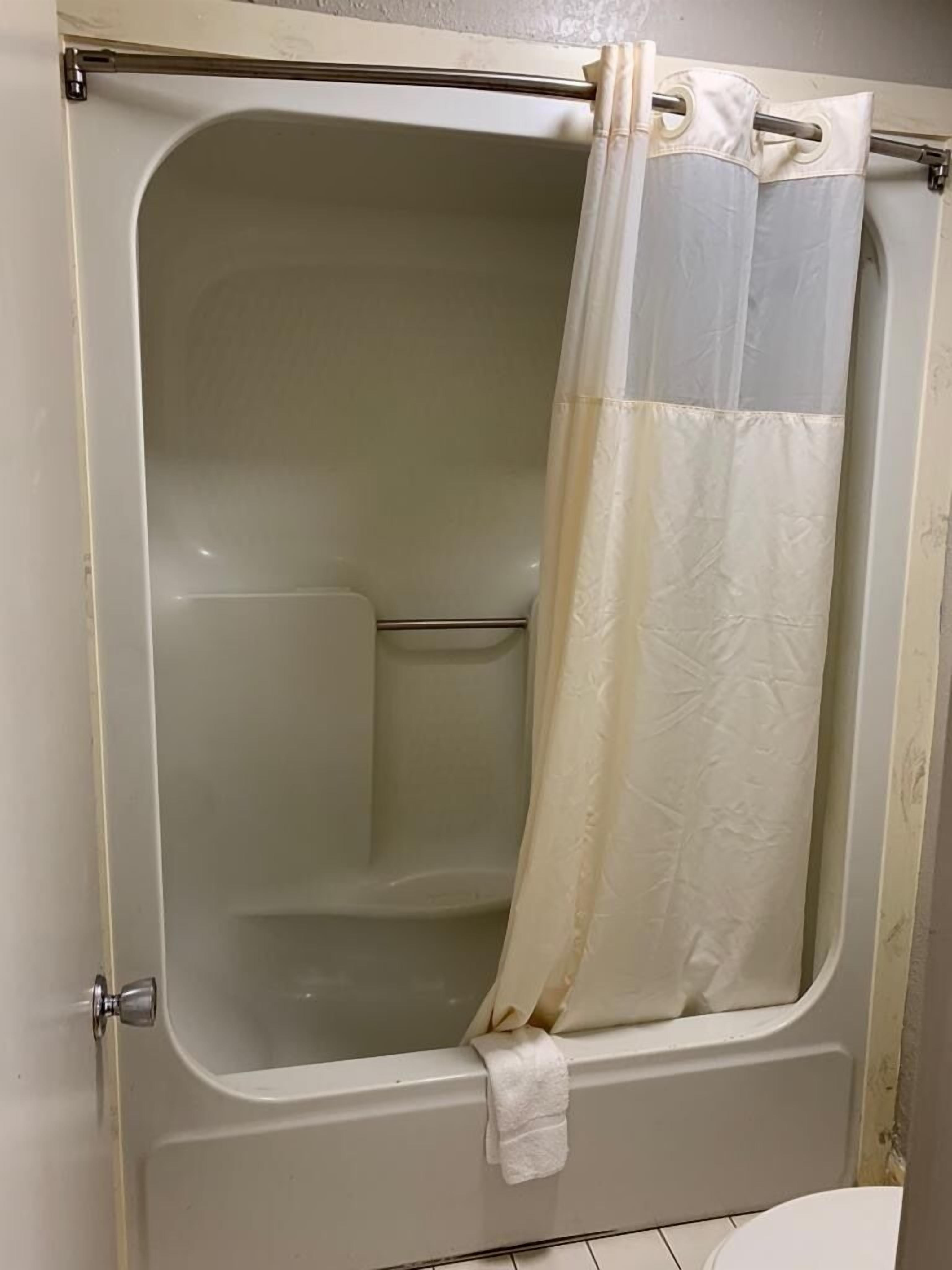 Una bañera con cortina de ducha.