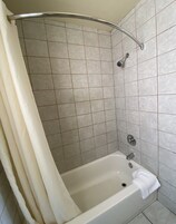 Bañera con ducha, artículos de tocador de diseñador, secador de pelo