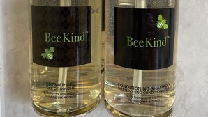 Two bottles of BeeKind shower gel and conditioning shampoo with pump dispensers, labeled with honey and organic lemongrass extracts. - Holiday Motel (Morgan Hill)