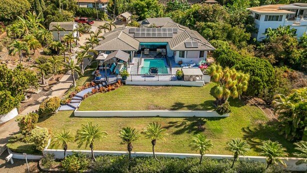 A residential property with a swimming pool, solar panels, and a well-maintained garden.