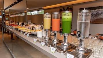 A buffet with various food and drink options, including a juice bar with multiple dispensers.