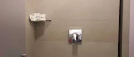 Una ducha con cabezal de ducha de mano y panel de control.