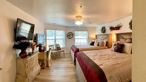 A bedroom with two beds, a desk, a chair, a television, and a ceiling fan. - Walk in level. 3 King beds, , massage chair. Water Bubble Cascade . (Branson)