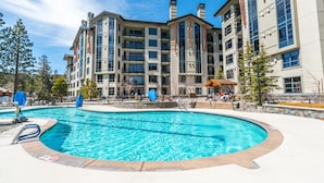 Un hôtel doté d’une piscine, de plusieurs balcons et d’une façade en pierre.
