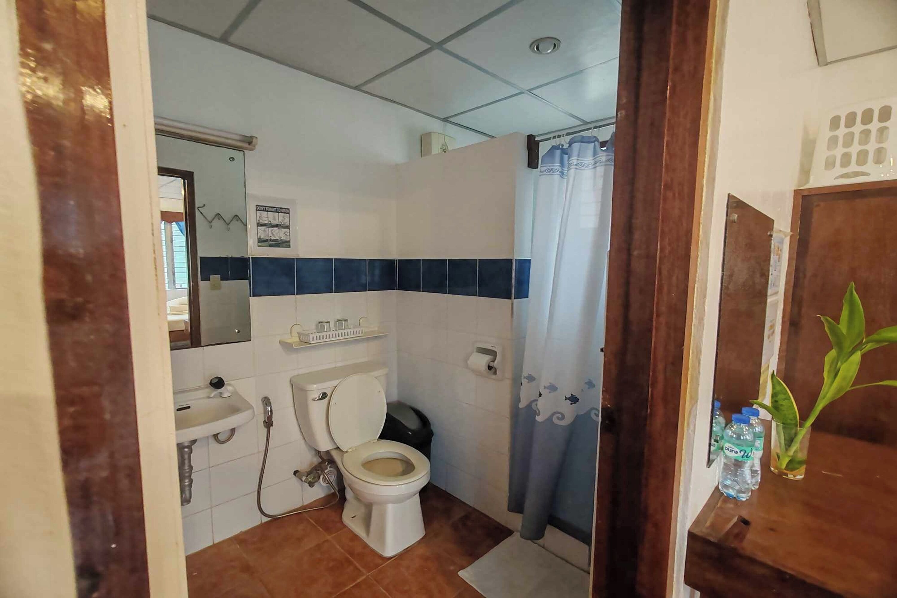 A bathroom with a toilet, sink, and shower area.