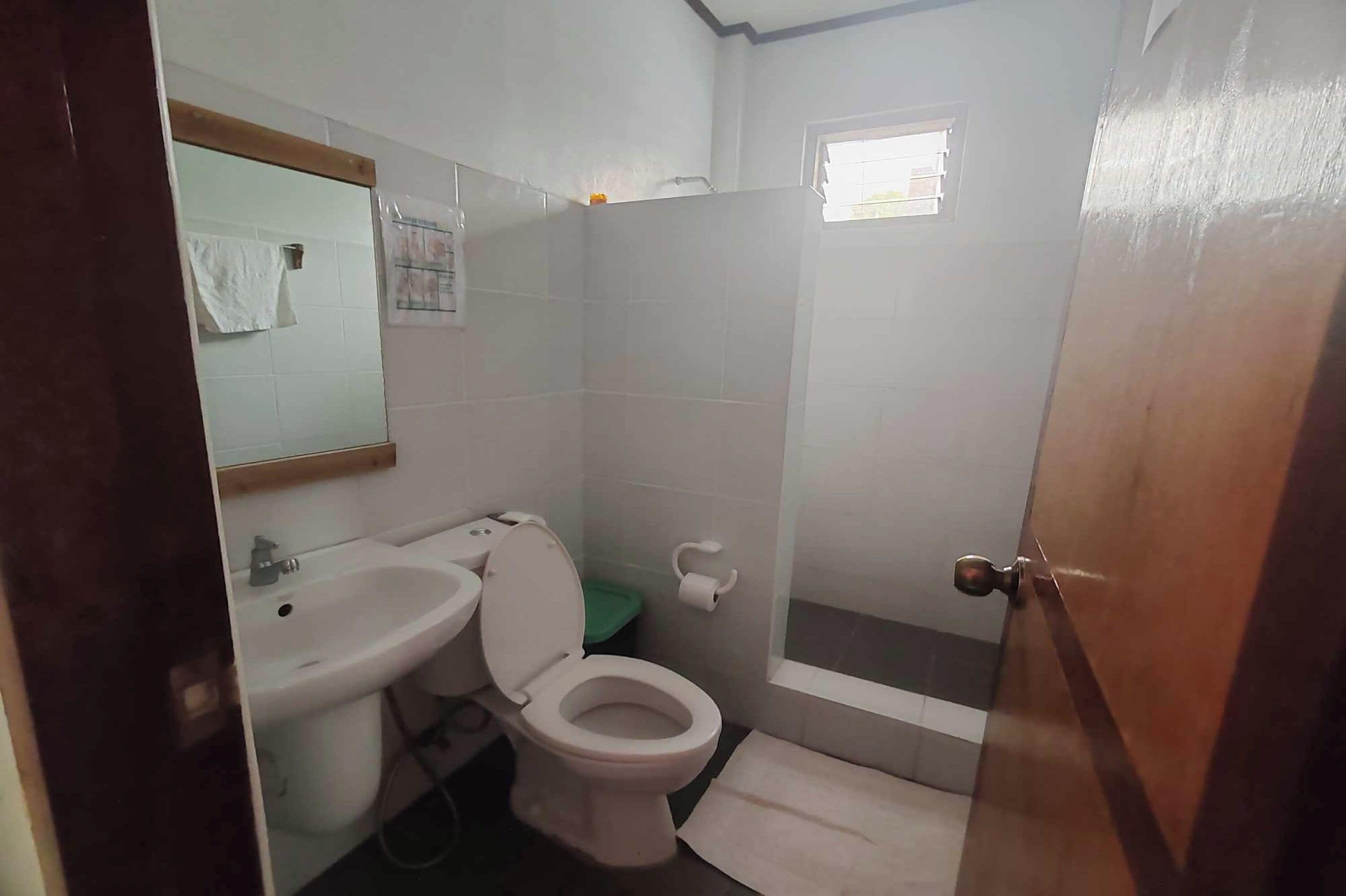 Un baño pequeño con inodoro, lavamanos y espejo.