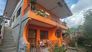 Un edificio de dos plantas con un balcón en el piso superior.