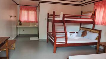 A bunk bed room with a desk and a small table.