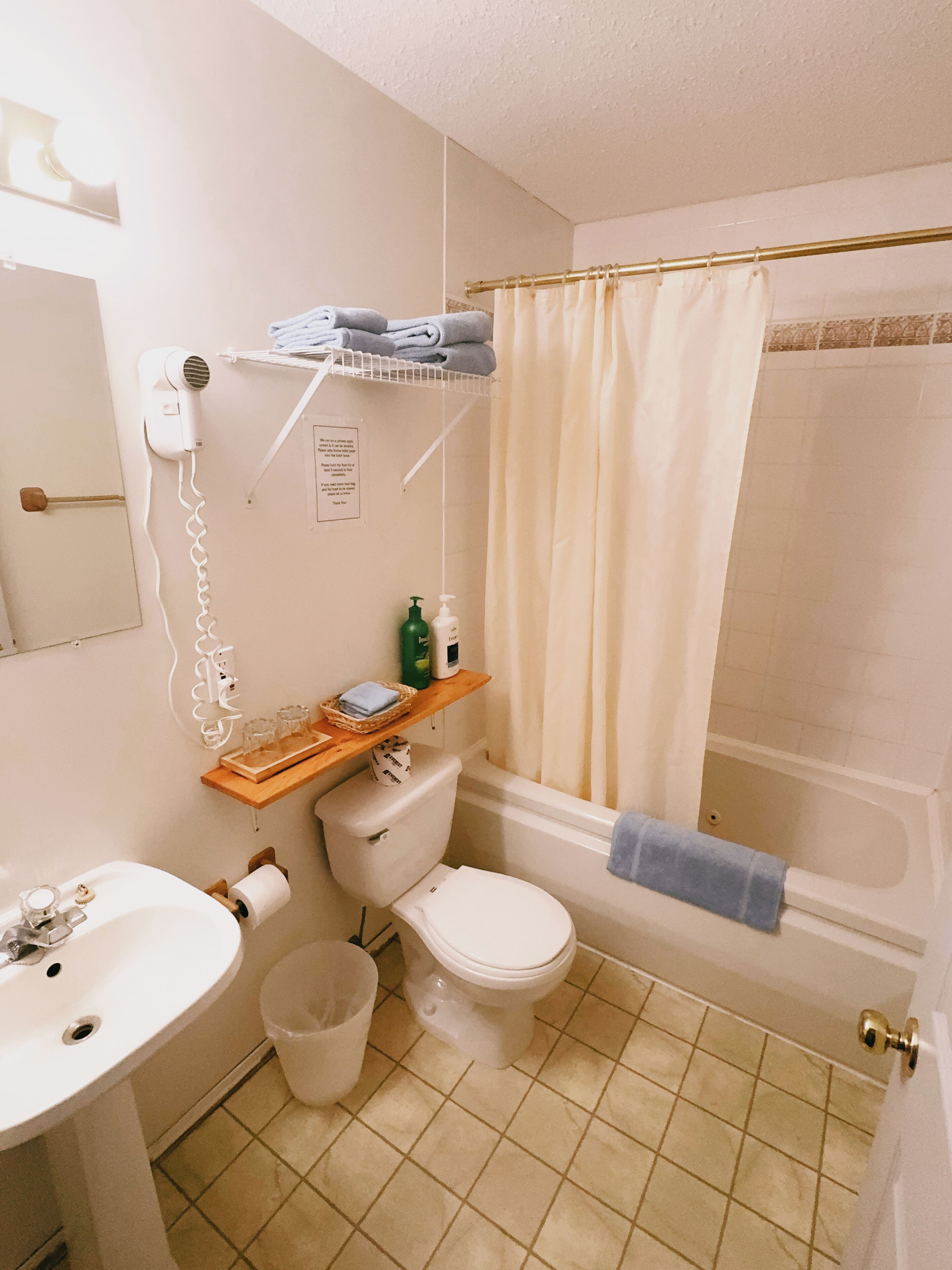 A bathroom with a toilet, sink, and shower area.