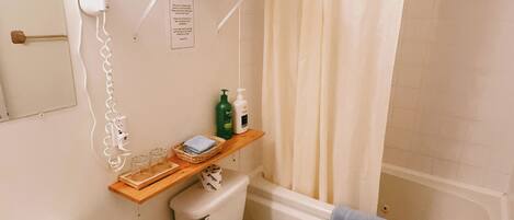 A bathroom with a toilet, sink, and shower area.