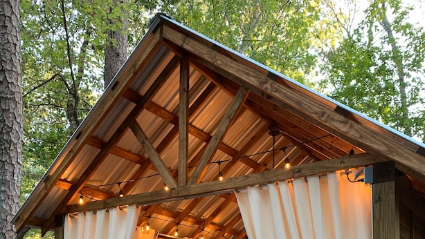 A rustic wooden cabin with a loft bed and a small seating area.