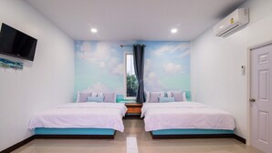 A room with two beds, a TV, an air conditioner, and a mural of clouds on the wall. - Baan Farm Sook (Cha-am)