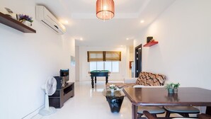 A modern living room with a pool table, a sofa, and a dining table. - Baan Farm Sook (Cha-am)