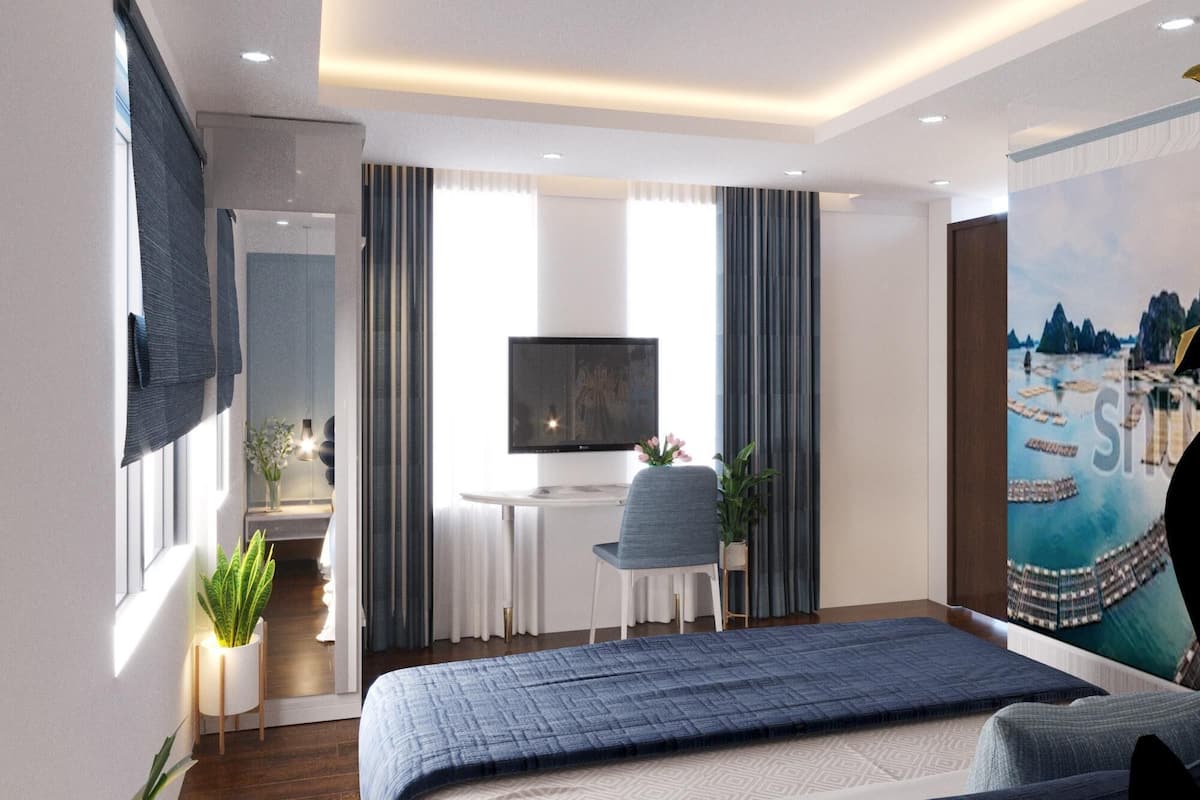 Une chambre d’hôtel moderne avec un grand lit, un bureau avec une télévision, une chaise et un tableau au mur.