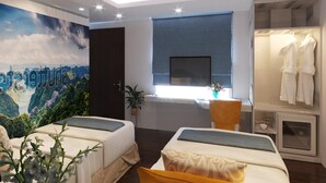 Een moderne hotelkamer met twee bedden, een grote muurschildering, een televisie en een garderobe.