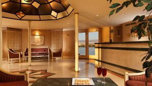 A lobby with a reception desk, seating area, and a view of the sea. - Jaz Monarch Nile Cruise - Every Monday from Luxor for 07 and 04 Nights - Every Friday From Aswan for 03 Nights (Luxor)