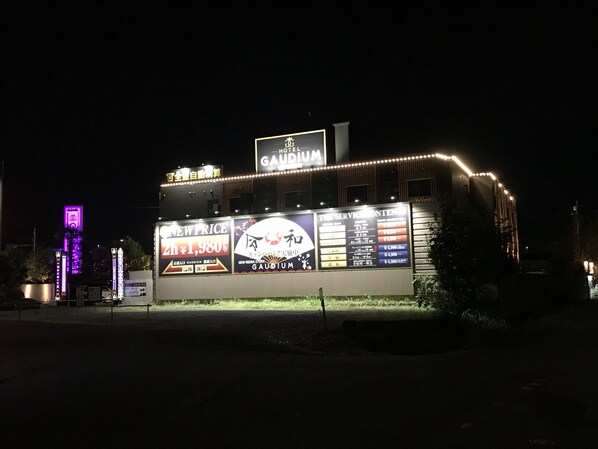 A hotel with illuminated signage and a prominent 'NEW PRICE' banner.