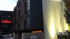 A modern building with a sign reading "GAUDIUM" and a neon "Welcome" sign. - Hotel Gaudium - Adult Only (Kuki)
