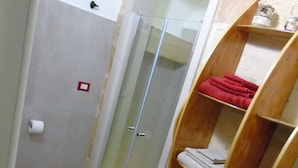 A bathroom with a shower, toilet, and wooden shelving unit. - Casa a Corte (Copertino)
