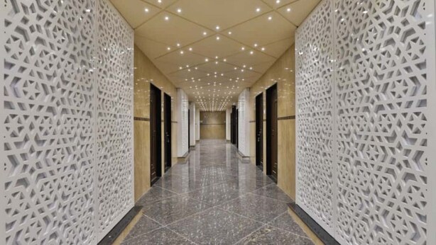 A hallway with patterned walls and a tiled floor, leading to a door at the end. - Hotel Centre Point (Mundra)