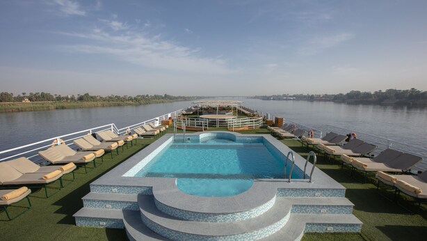 A pool area with lounge chairs and a central pool on a boat. - Jaz Celebrity Nile Cruise - Every Saturday from Luxor for 07 and 04 Nights - Every Wednesday From Aswan for 03 Nights (Luxor)