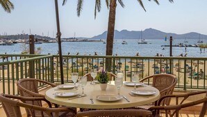 Un área de comedor al aire libre con vista al mar y a las embarcaciones.